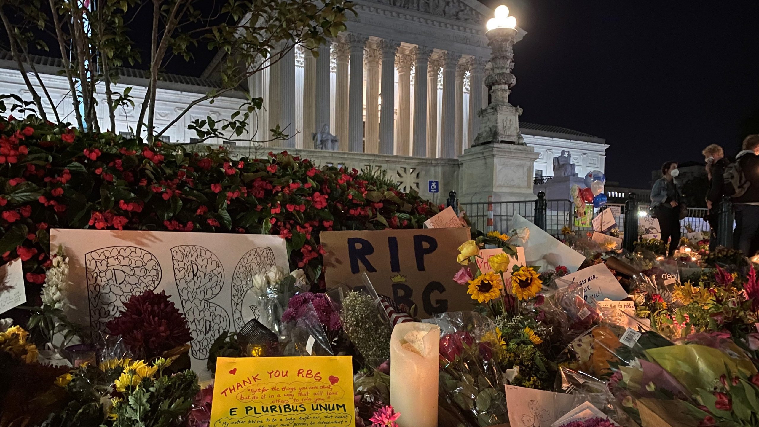 Photo of flowers and signs in front of the US Supreme Court.